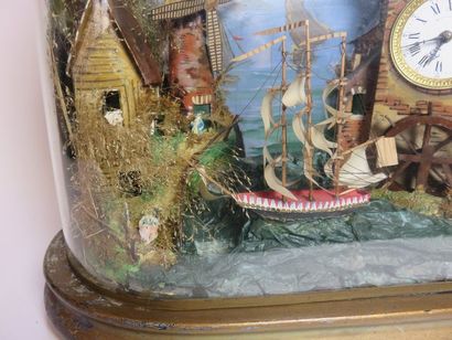 Pendule automate sous globe. A droite, un...