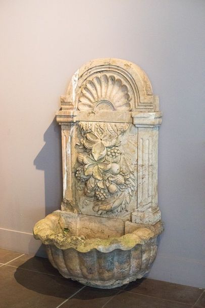 Fontaine en marbre. Le fronton, à décor sculpté...