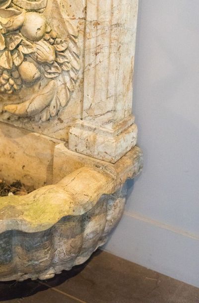 Fontaine en marbre. Le fronton, à décor sculpté...