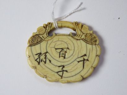 CHINE Pendentif en ivoire gravé d'idéogrammes...