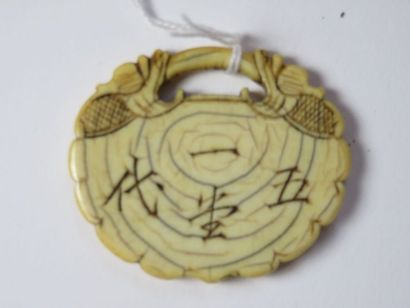 CHINE Pendentif en ivoire gravé d'idéogrammes...