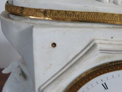 Pendule en biscuit et ornementation de bronzes....