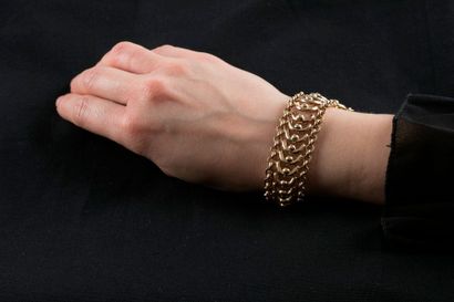 Bracelet souple en or jaune retenant au centre...