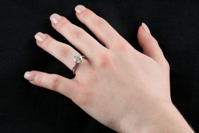 Bague solitaire en or gris retenant un diamant...