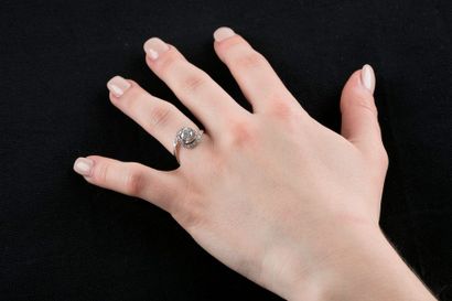 Bague solitaire en or gris retenant un diamant...