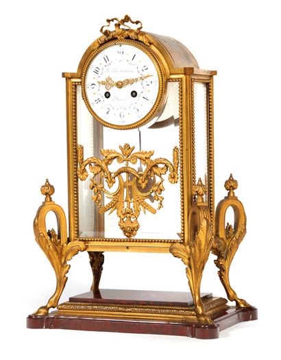 Clock 
of cage form in chased and gilded...