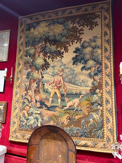 Tapestry with a trainer and his dog on a...
