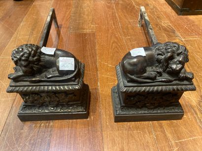 Two small andirons decorated with reclining...