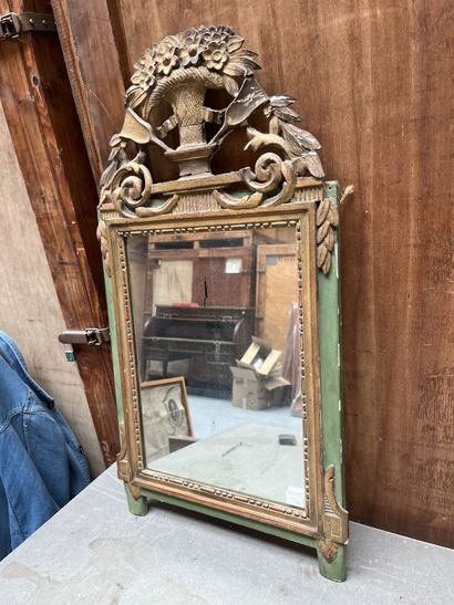 Miroir en bois doré et laqué vert. Le fronton...
