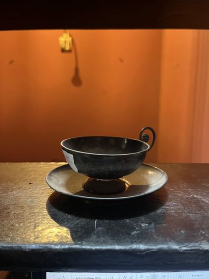 Silver cup and saucer with incised flower...