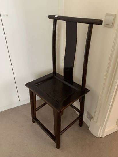 Une chaise à haut dossier en bois naturel...