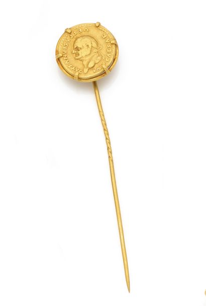 Epingle 
en or 18K (750), sommée d'une monnaie...