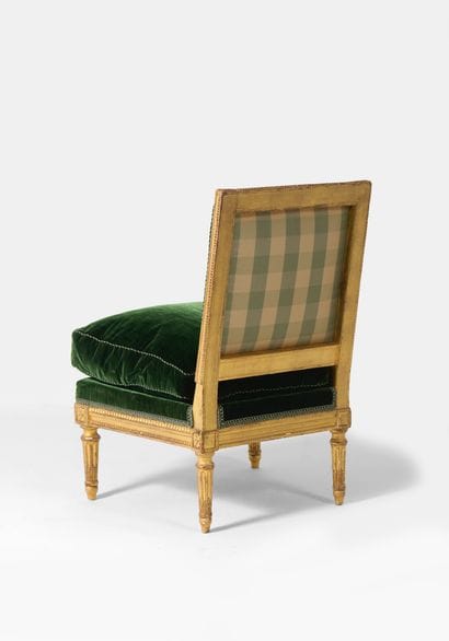 Chaise basse 
en bois redoré, à dossier rectangulaire...