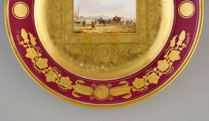 BELLE ASSIETTE EN PORCELAINE. À décor central...