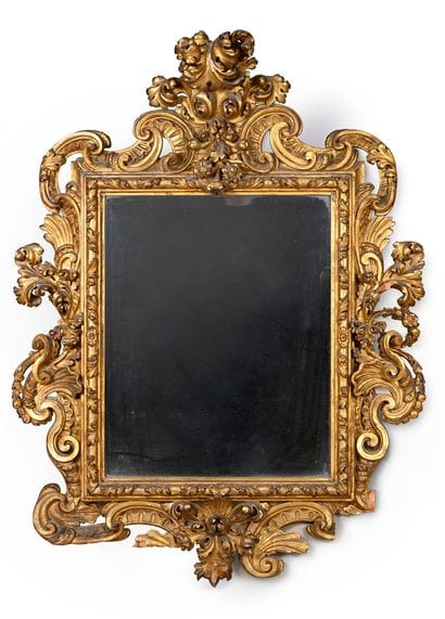 Molded, carved and gilded wood mirror, the...