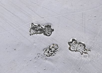 Porte huilier et ses bouchons en argent reposant...