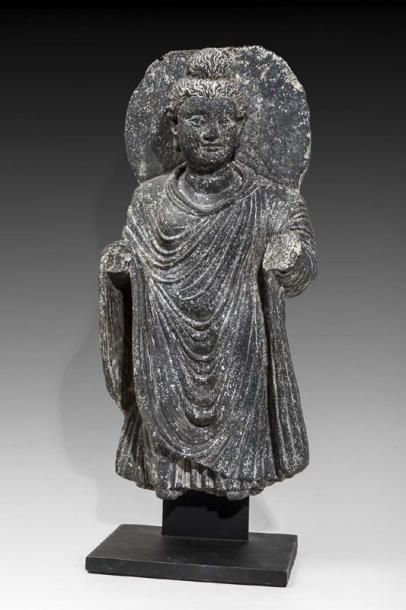 Bouddha auréolé représenté debout, portant...