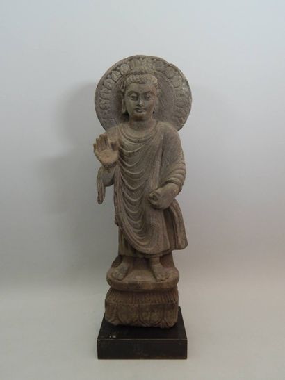 Bouddha auréolé debout sur un piédestal orné...