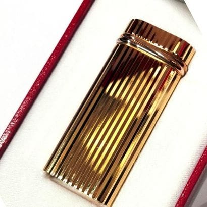 CARTIER - BRIQUET en métal doré, à décor...