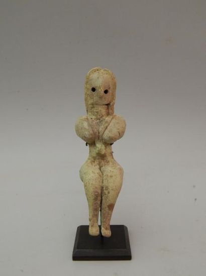 Idole féminine assise, les bras sous les...