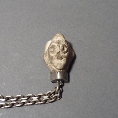 Tête en terre cuite (montée en pendentif)....