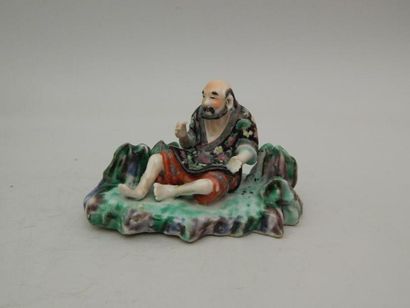 Vieillard assis en porcelaine émaillée polychrome....