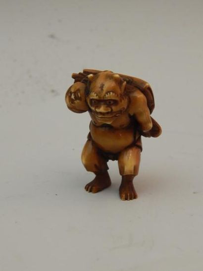 Netsuke en ivoire représentant un Oni portant...