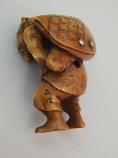 Netsuke en ivoire représentant un Oni portant...