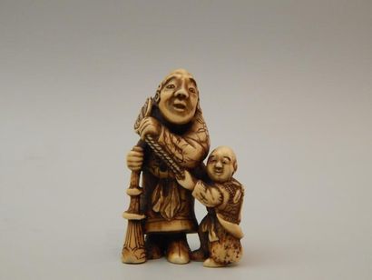 Netsuke en ivoire représentant un homme tenant...