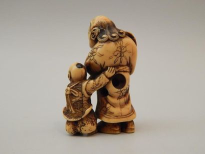 Netsuke en ivoire représentant un homme tenant...