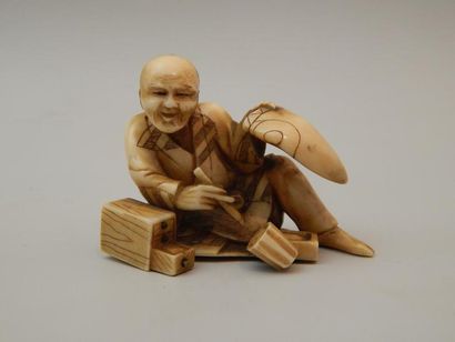 Sujet en ivoire représentant un artisan assis....