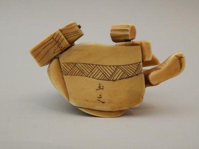 Sujet en ivoire représentant un artisan assis....