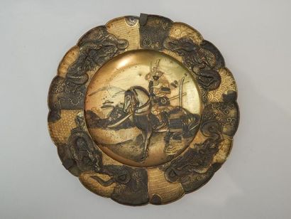 Deux assiettes en métal doré à décor de samouraï....