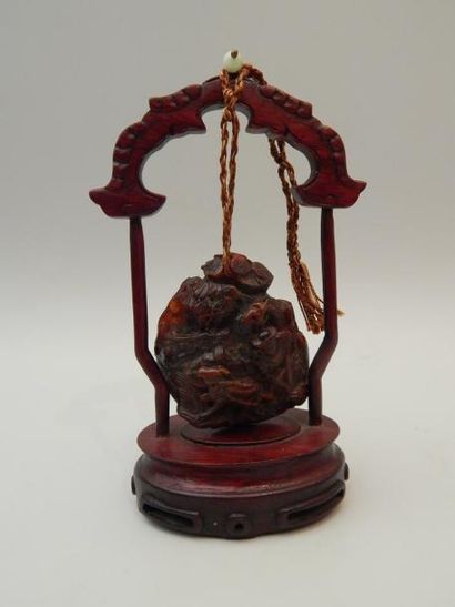 Pendentif en ambre à décor sculpté de personnages,...