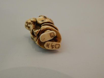 Netsuke en ivoire. Colporteur debout ayant...