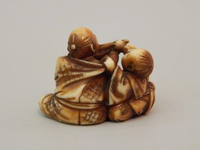 Netsuke en ivoire. Homme nourrissant son...