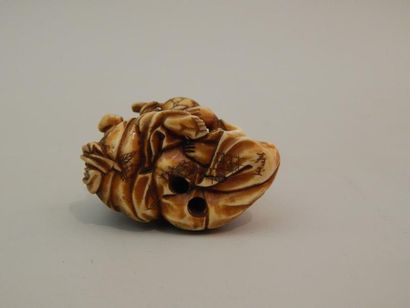 Netsuke en ivoire. Homme nourrissant son...