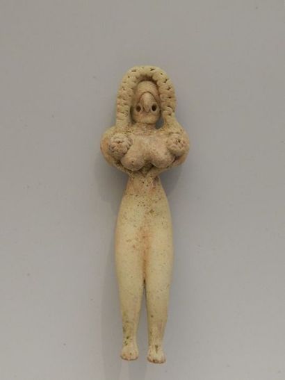 Idole féminine assise, les mains placées...