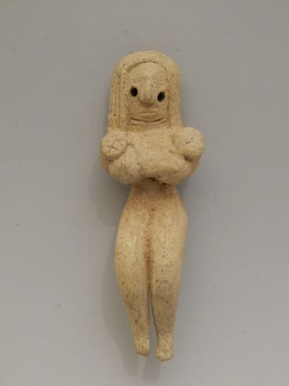 Idole féminine assise, les mains placées...