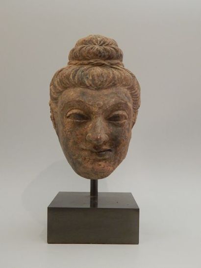 Tête de Bouddha en terre cuite. H : 21 cm....
