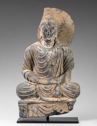 Bouddha auréolé assis sur un trône en méditation....