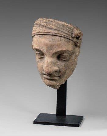 Visage de servant au turban. En terre cuite....