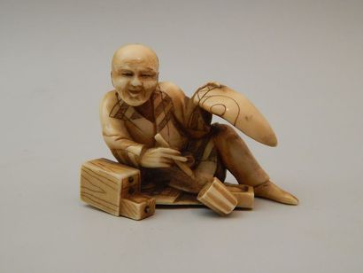 Sujet en ivoire représentant un artisan assis....