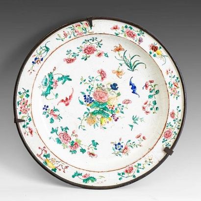 Plat rond en cuivre émaillé à décor de fleurs....