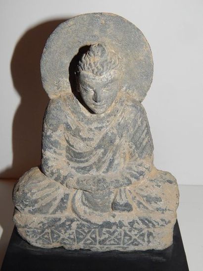 Bouddha auréolé assis sur un trône en position...