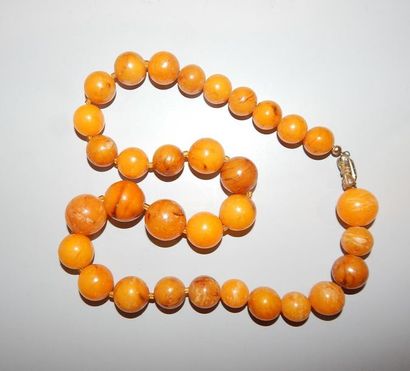 Collier en perles d’ambre (?). L : 54 cm....