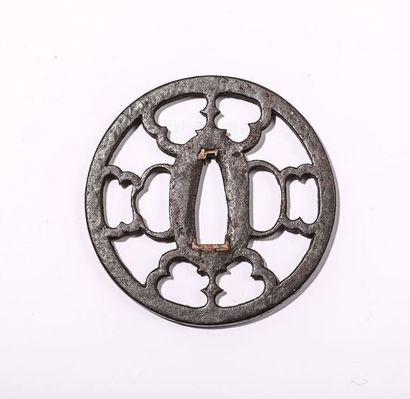 Tsuba en fer, à décor floral. H : 7,4 cm....