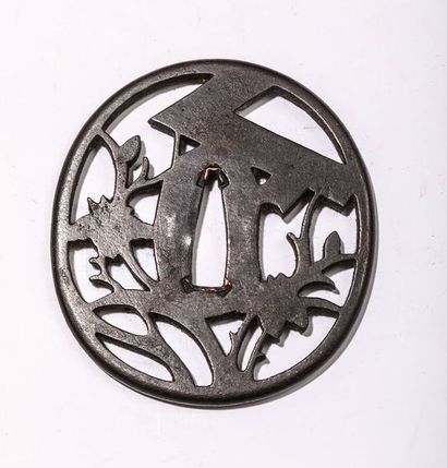 Tsuba en fer, à décor ajouré. H : 8,1 cm....