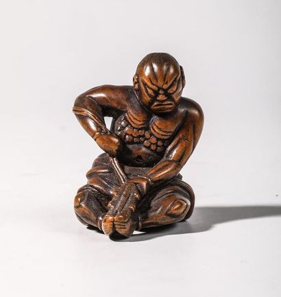 Netsuke en buis, représentant un oni assis....