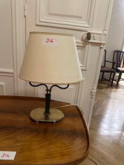 1 two-arm brass table lamp on oval base resting...